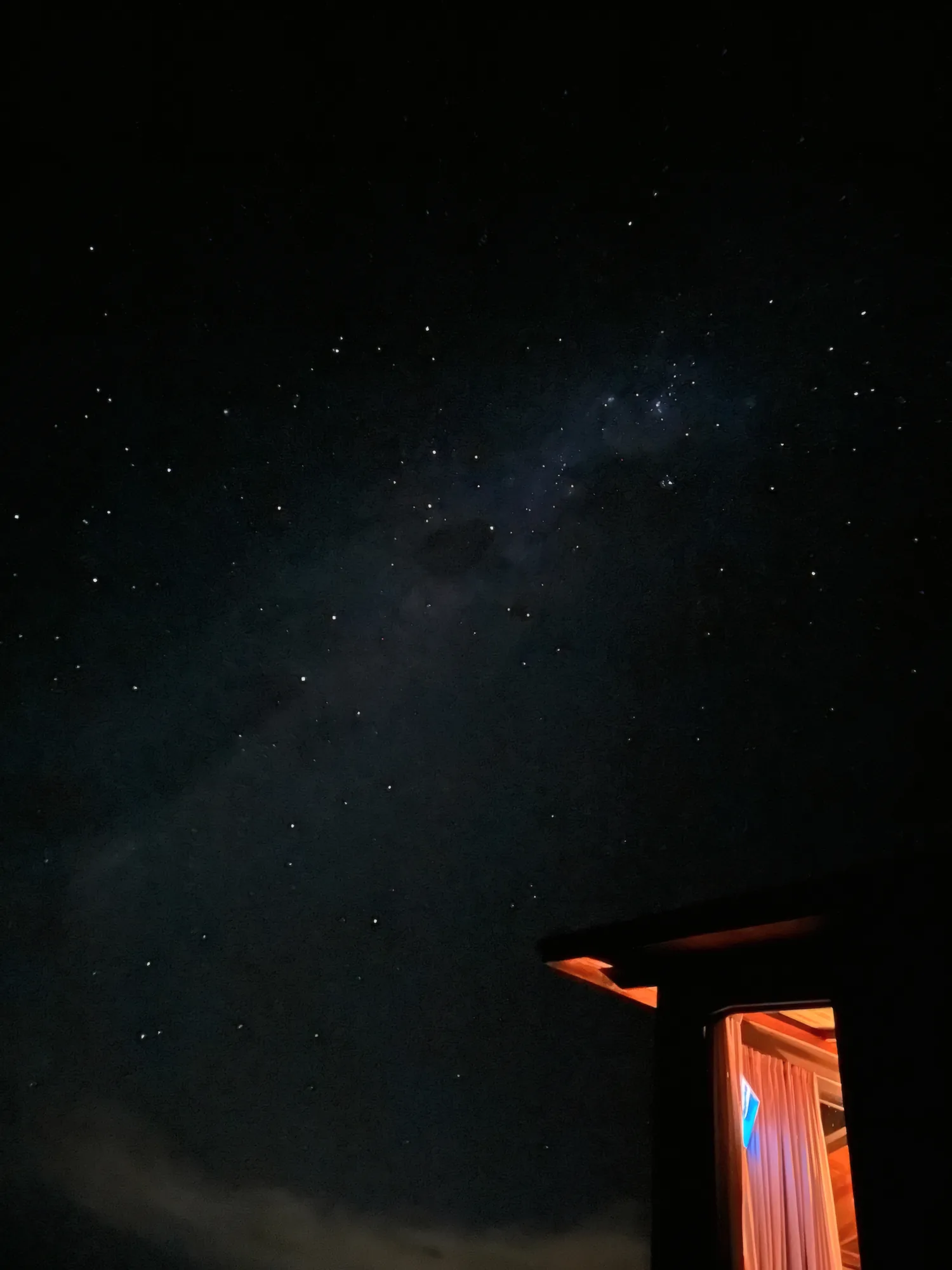 Céu estrelado sobre a cabana iluminada