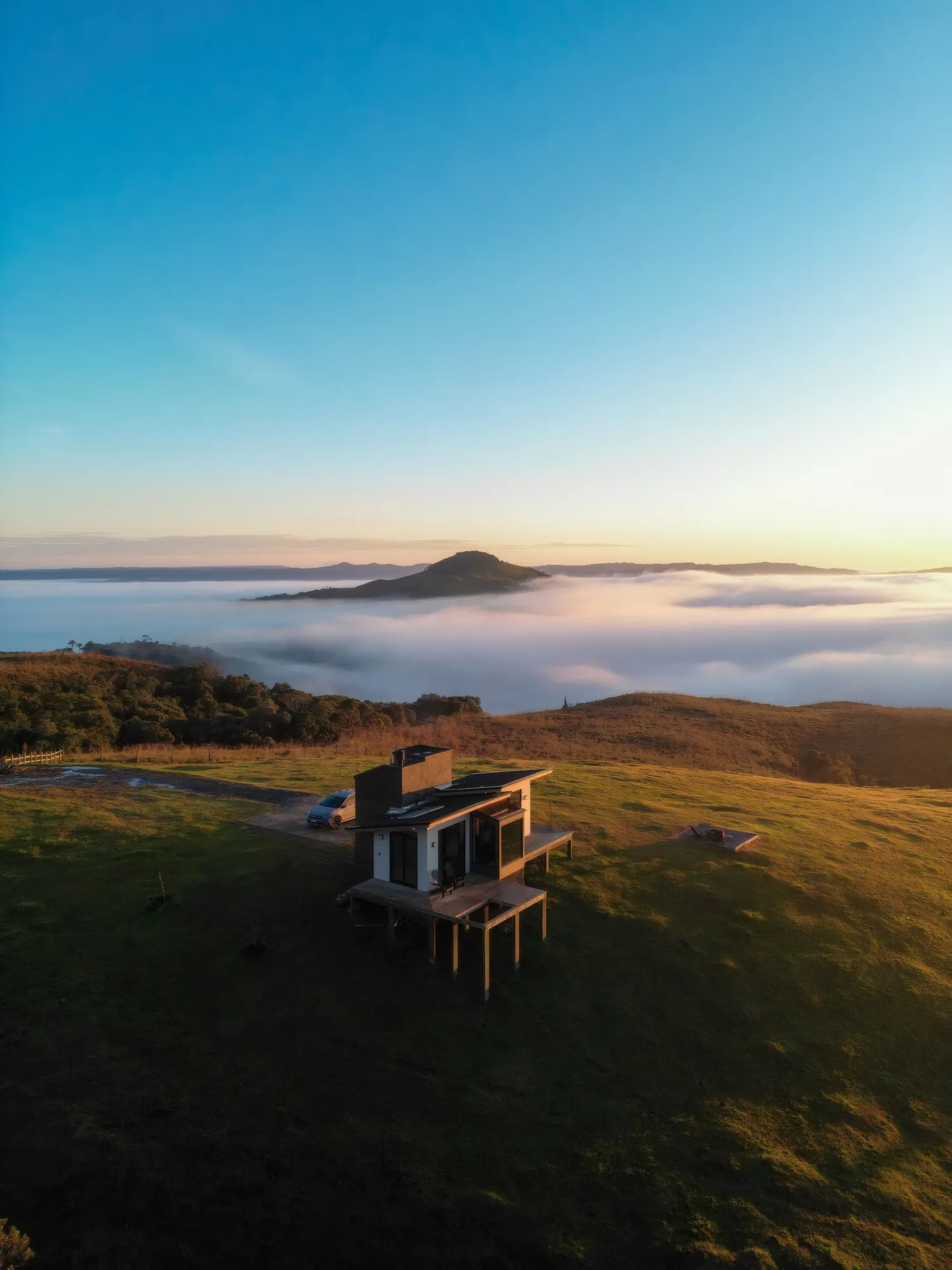 Sunrise Home no alto da montanha, diante de um mar de nuvens ao amanhecer