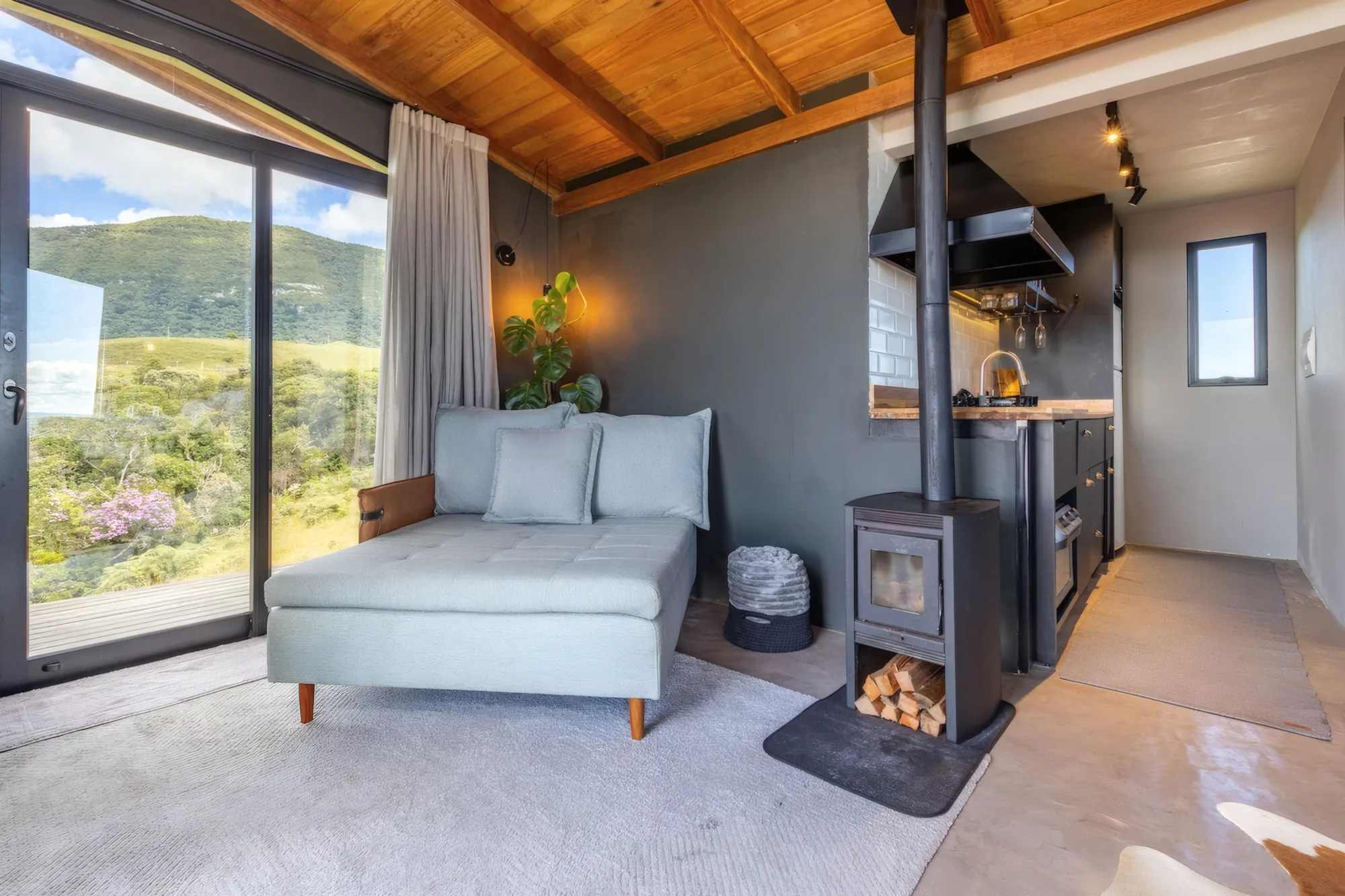 Sala com chaise, calefator a lenha e cozinha integrada