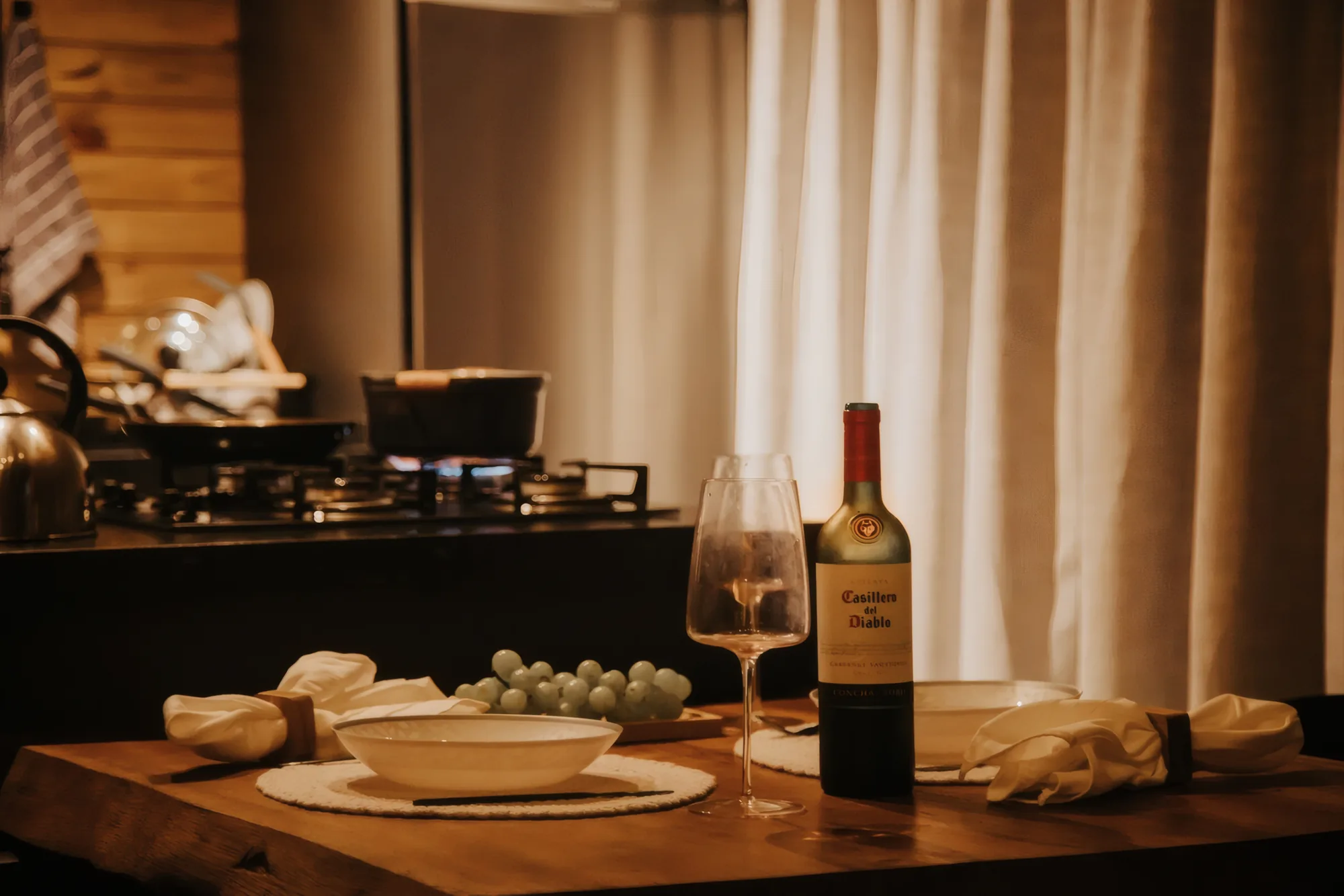 Mesa posta com vinho e frutas à luz de velas